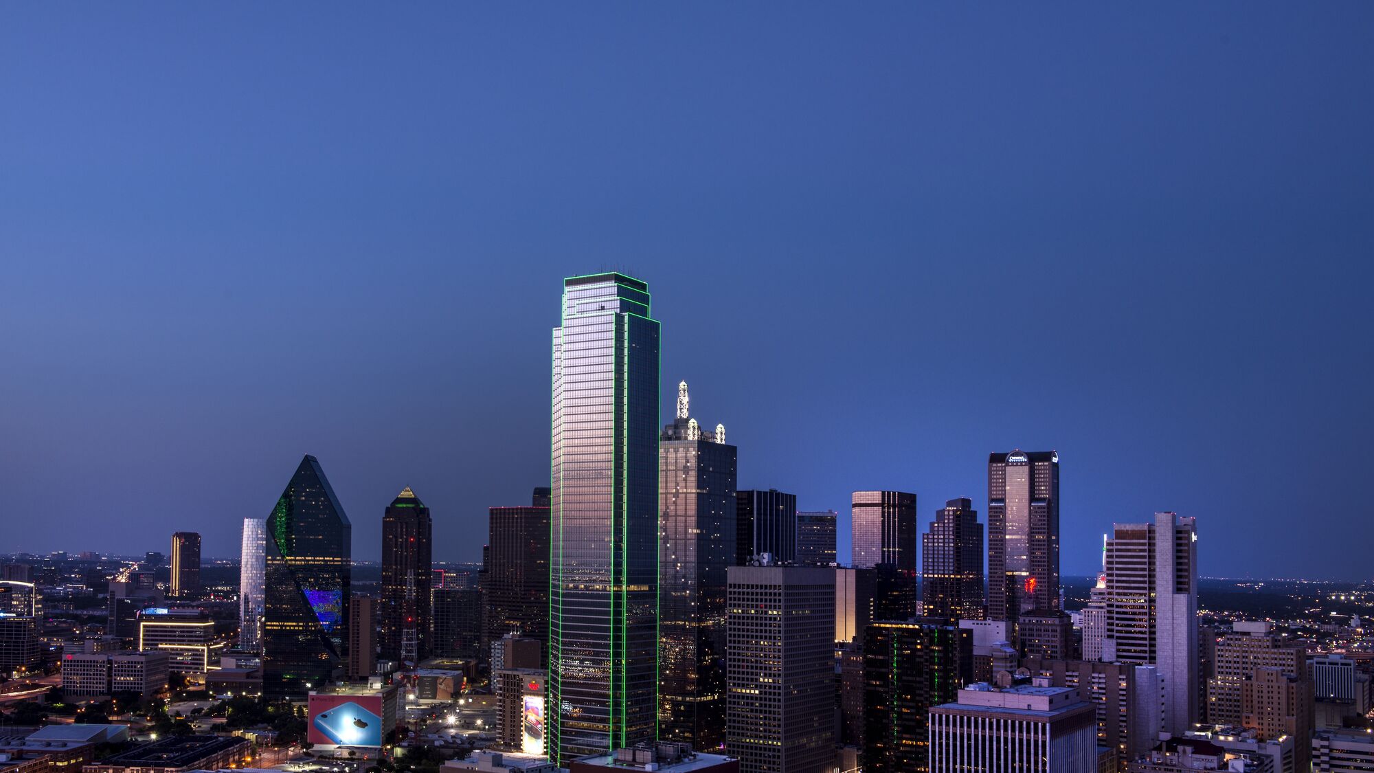 Downtown Dallas skyline at blue hour, shot from Reunion Tower ("the ball") -- Bank of America Plaza’s argon-green outline ("the green building", resident shibbo